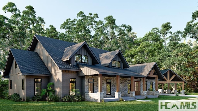 rear view of house featuring board and batten siding, covered porch, stone siding, and a lawn