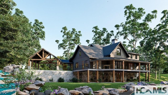 back of house featuring board and batten siding, stone siding, a lawn, and a chimney