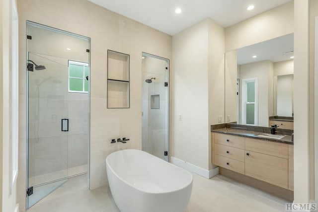 bathroom featuring vanity and separate shower and tub