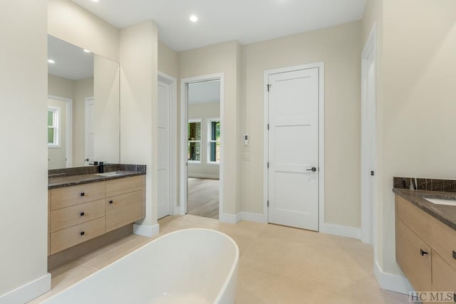 bathroom featuring a tub to relax in and vanity