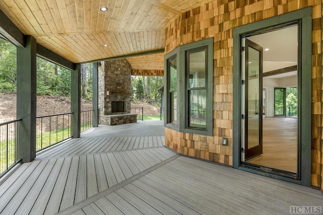 deck with an outdoor stone fireplace