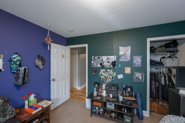 bedroom with carpet flooring, a textured ceiling, and a closet