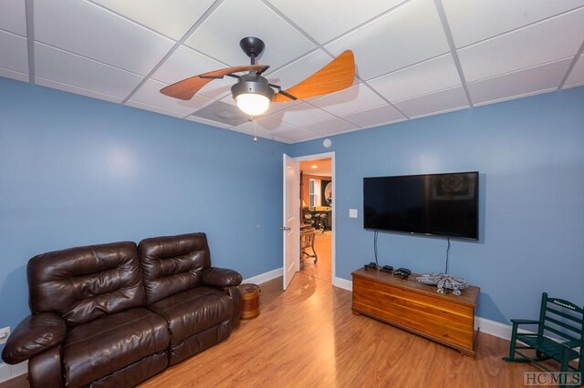 living room featuring a paneled ceiling, hardwood / wood-style floors, and ceiling fan