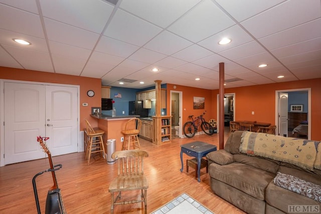 living room with bar area and light wood-type flooring