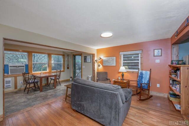 living room with cooling unit and light hardwood / wood-style flooring