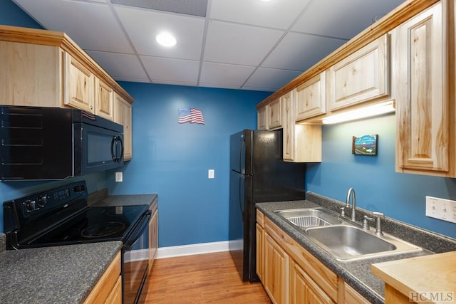 kitchen featuring a drop ceiling, light brown cabinetry, sink, and black appliances