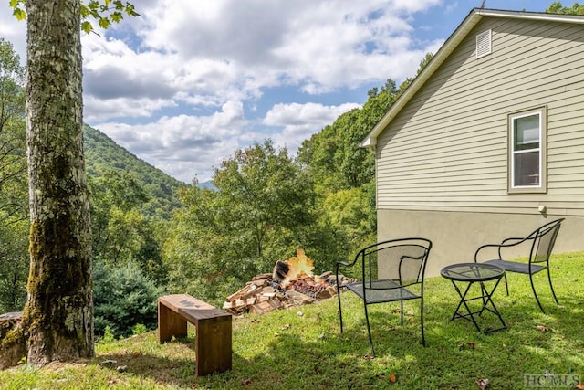 view of yard with a fire pit and a mountain view