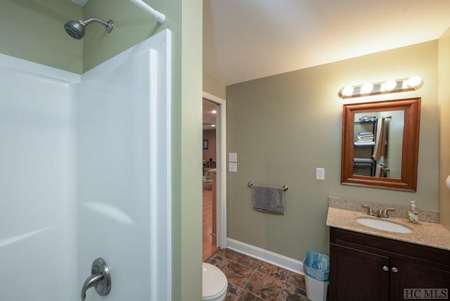 bathroom with toilet, vanity, and walk in shower