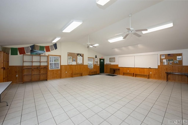 interior space featuring ceiling fan and wood walls