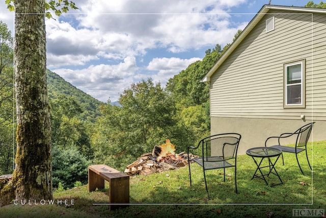 view of yard featuring a mountain view and a fire pit