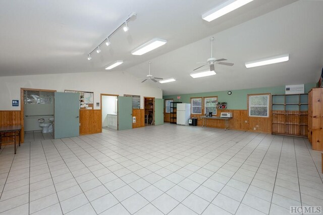 miscellaneous room with vaulted ceiling, light tile patterned flooring, ceiling fan, track lighting, and wooden walls