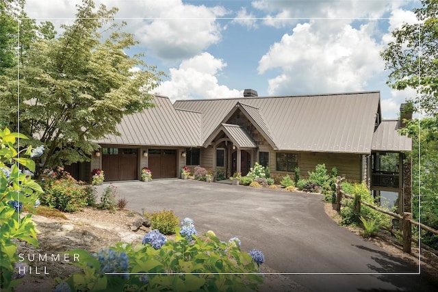 541 Summer Hill Rd, Cullowhee, NC 28723 - view of front of home featuring a chimney, driveway, a garage, stone siding, and a metal roof