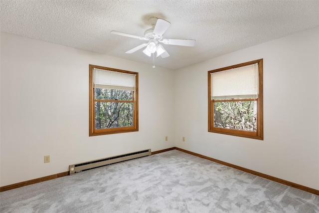 carpeted empty room featuring baseboards, a ceiling fan, a textured ceiling, and a baseboard heating unit