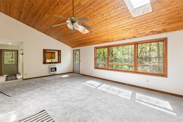 unfurnished living room with a skylight, wood ceiling, baseboards, and carpet