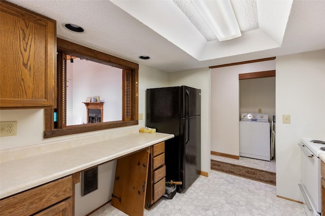 kitchen with baseboards, freestanding refrigerator, brown cabinets, and light countertops