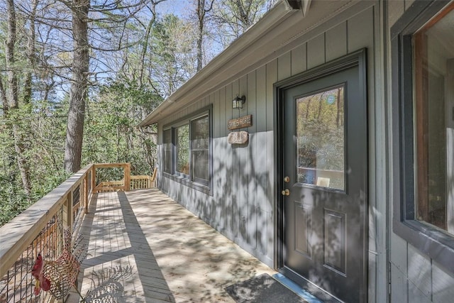 property entrance with board and batten siding and a deck