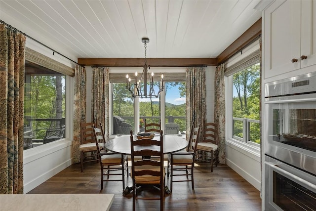 sunroom / solarium featuring an inviting chandelier, baseboards, and wood finished floors