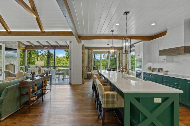 kitchen with double oven, stovetop, custom range hood, dark wood finished floors, and green cabinets