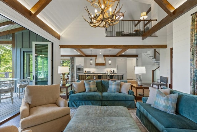 living area featuring a notable chandelier, wood walls, stairs, wood finished floors, and beamed ceiling