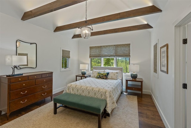 bedroom featuring baseboards, dark wood finished floors, and beam ceiling