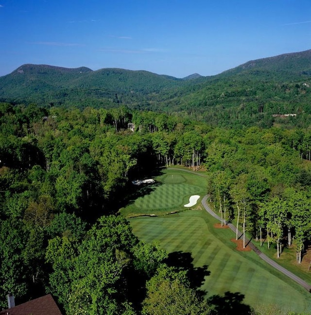 aerial view featuring a view of trees, a mountain view, and view of golf course