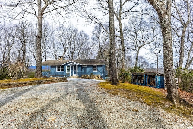 view of front of house featuring driveway and a chimney