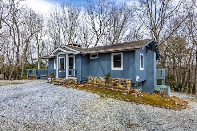 view of front of property featuring a porch and gravel driveway