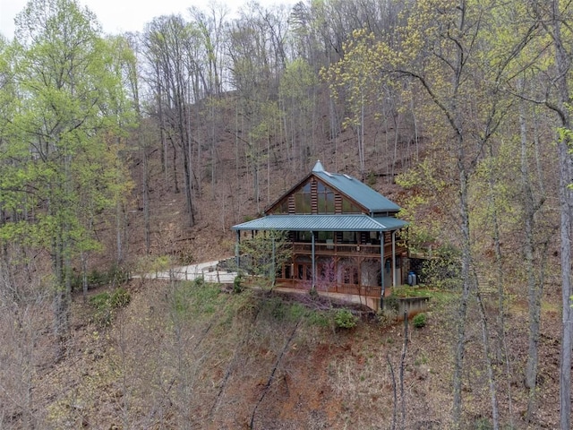 exterior space with a wooded view and a porch