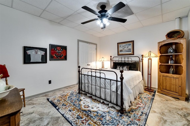 bedroom featuring a paneled ceiling, baseboards, and ceiling fan