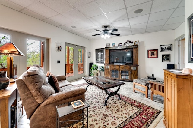 living room featuring french doors, ceiling fan, and a drop ceiling