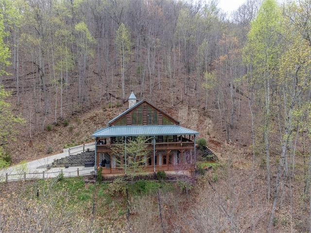 view of front facade with a view of trees and metal roof
