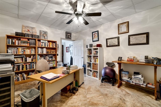 office with a drop ceiling and a ceiling fan
