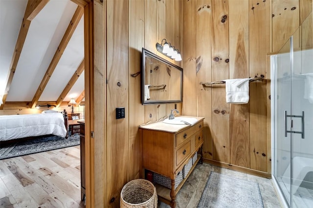 bathroom with beamed ceiling, a shower stall, connected bathroom, vanity, and wood walls