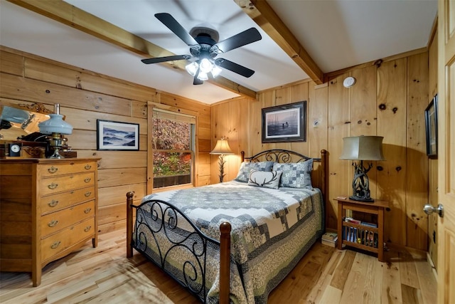 bedroom featuring beam ceiling, light wood-type flooring, and wood walls