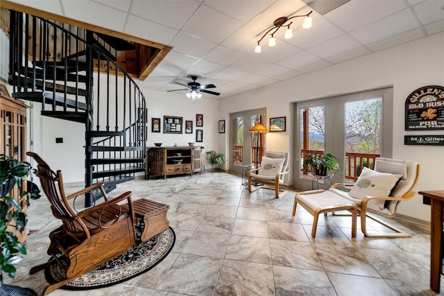 living room with a paneled ceiling, tile patterned floors, french doors, stairs, and ceiling fan