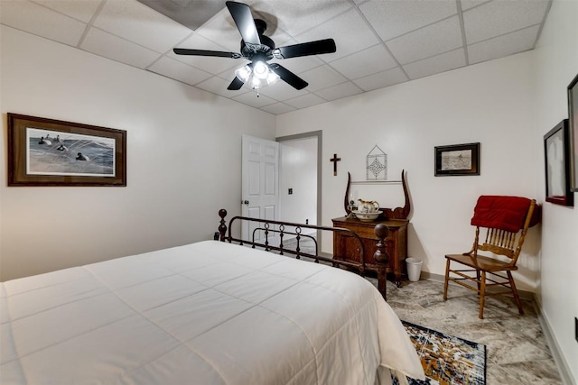 bedroom with a paneled ceiling, ceiling fan, and baseboards