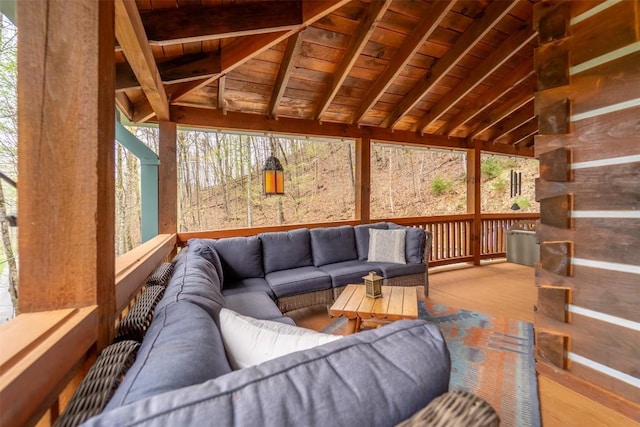 sunroom / solarium featuring beam ceiling and outdoor lounge area