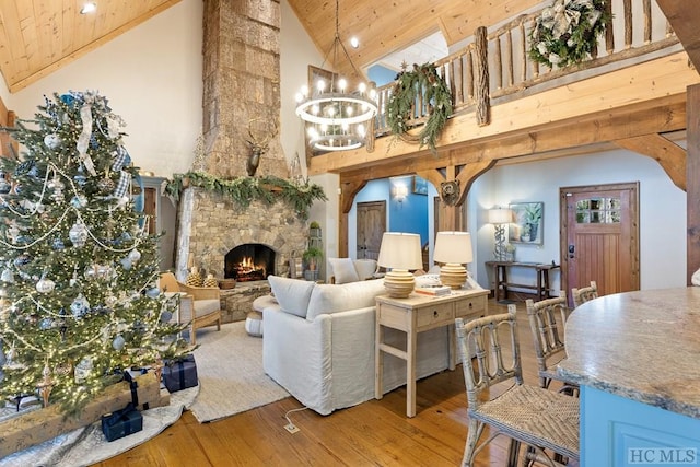 living area with wood-type flooring, a fireplace, wood ceiling, and a notable chandelier