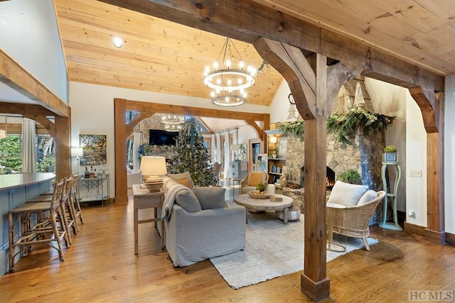 living area featuring an inviting chandelier, high vaulted ceiling, arched walkways, and wood finished floors