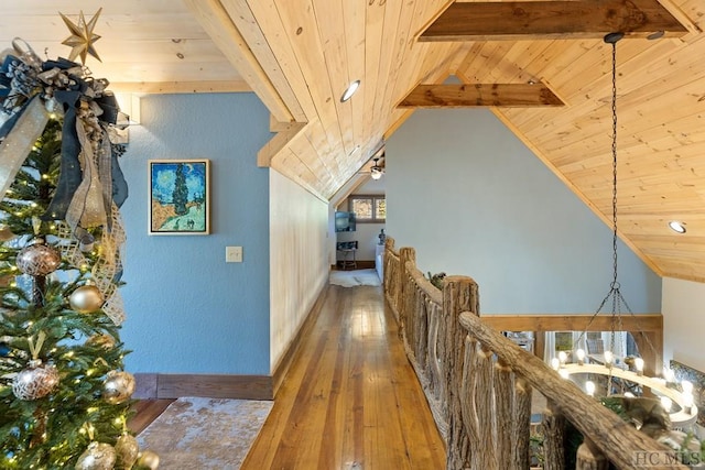 corridor featuring vaulted ceiling with beams, wooden ceiling, hardwood / wood-style floors, and an upstairs landing