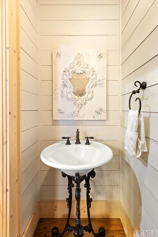 bathroom featuring a sink and wooden walls