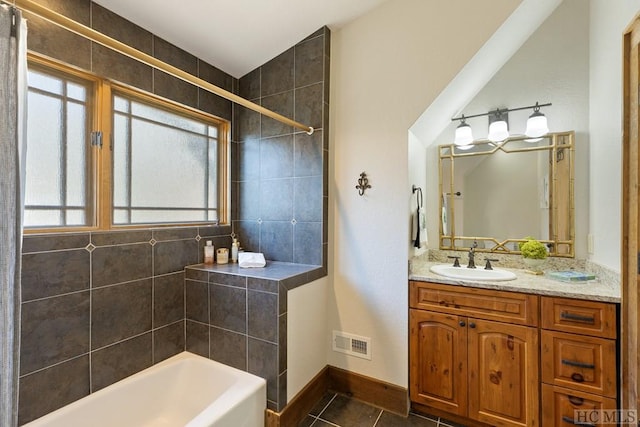 bathroom featuring a washtub, vanity, visible vents, a tile shower, and tile patterned floors