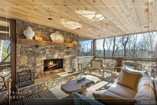 interior space with a stone fireplace, plenty of natural light, and wood ceiling