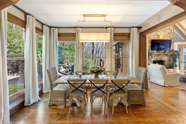 sunroom / solarium featuring a lit fireplace