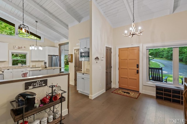 foyer entrance featuring beam ceiling, high vaulted ceiling, dark hardwood / wood-style floors, a notable chandelier, and wooden ceiling