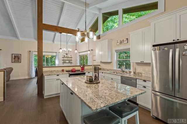 kitchen with a breakfast bar, an inviting chandelier, appliances with stainless steel finishes, pendant lighting, and white cabinets