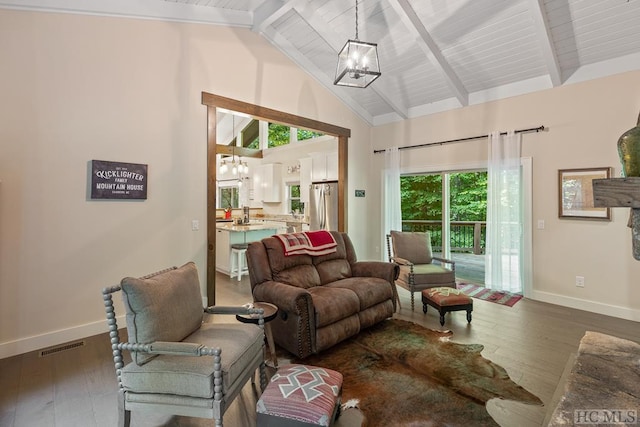 living room featuring lofted ceiling with beams, dark hardwood / wood-style floors, and a chandelier