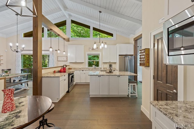 kitchen featuring white cabinetry, light stone countertops, a chandelier, and appliances with stainless steel finishes