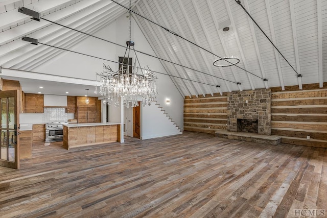 unfurnished living room featuring hardwood / wood-style floors, a fireplace, and high vaulted ceiling