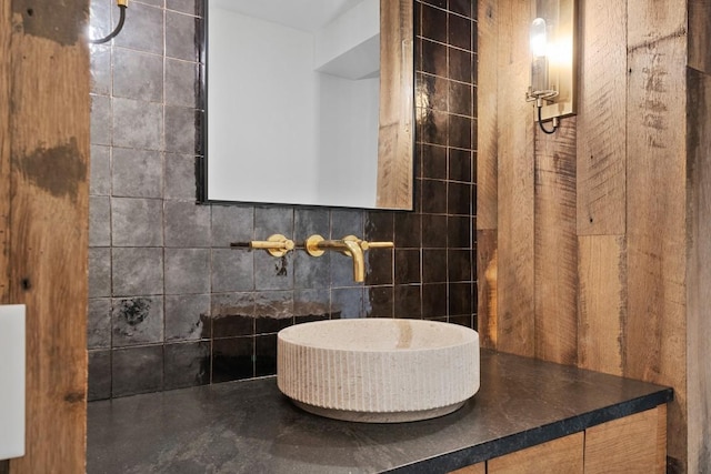 bathroom featuring sink and tile walls